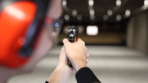 A woman aiming to fire at the target