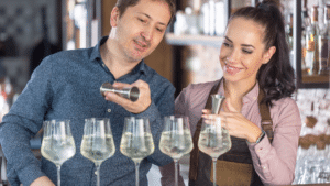 A man and a woman mixing beverages