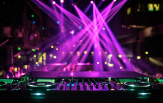 A Dj's turntable on pink spotlights