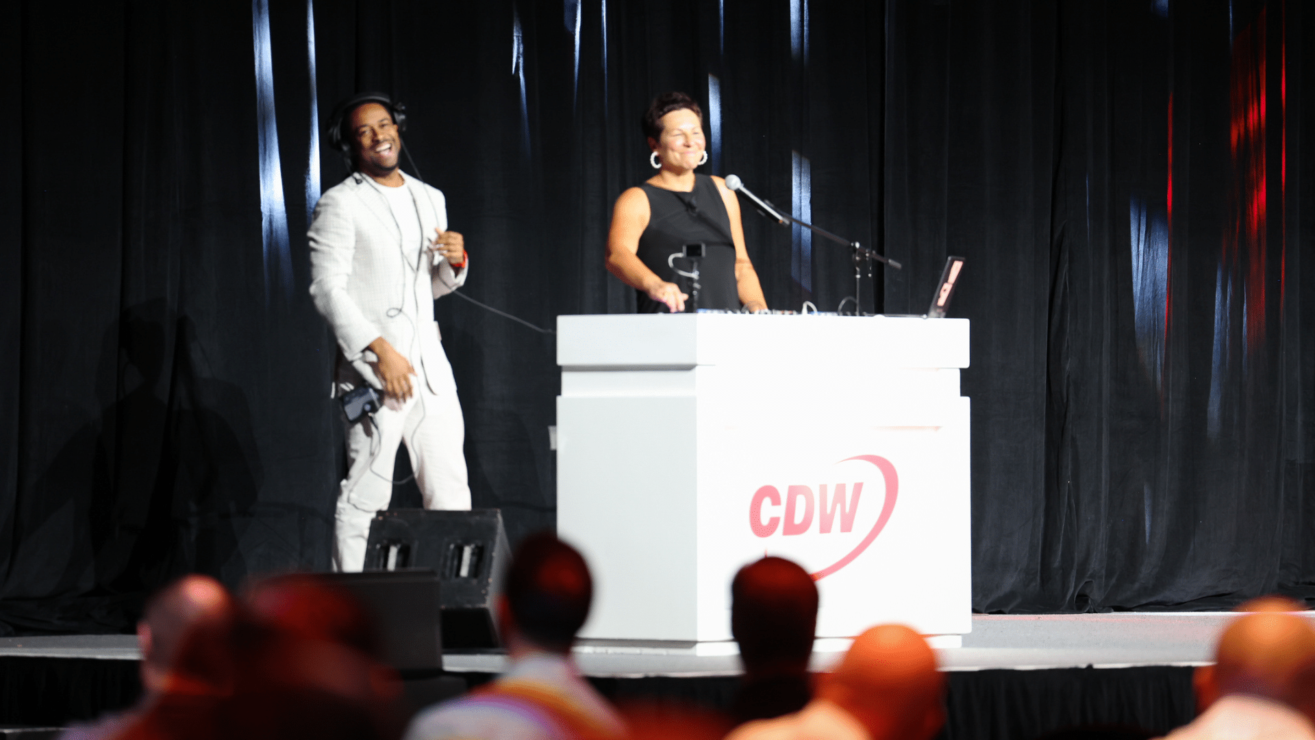 Las Vegas Event Emcee Will Gill is onstage teaching CDW President Chris Leahy How to DJ