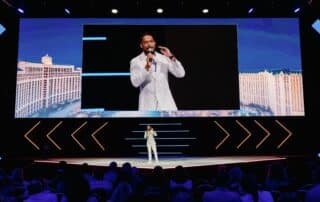 Corporate Emcee Will Gill on stage and big screen at a corporate event in Las Vegas.jpeg