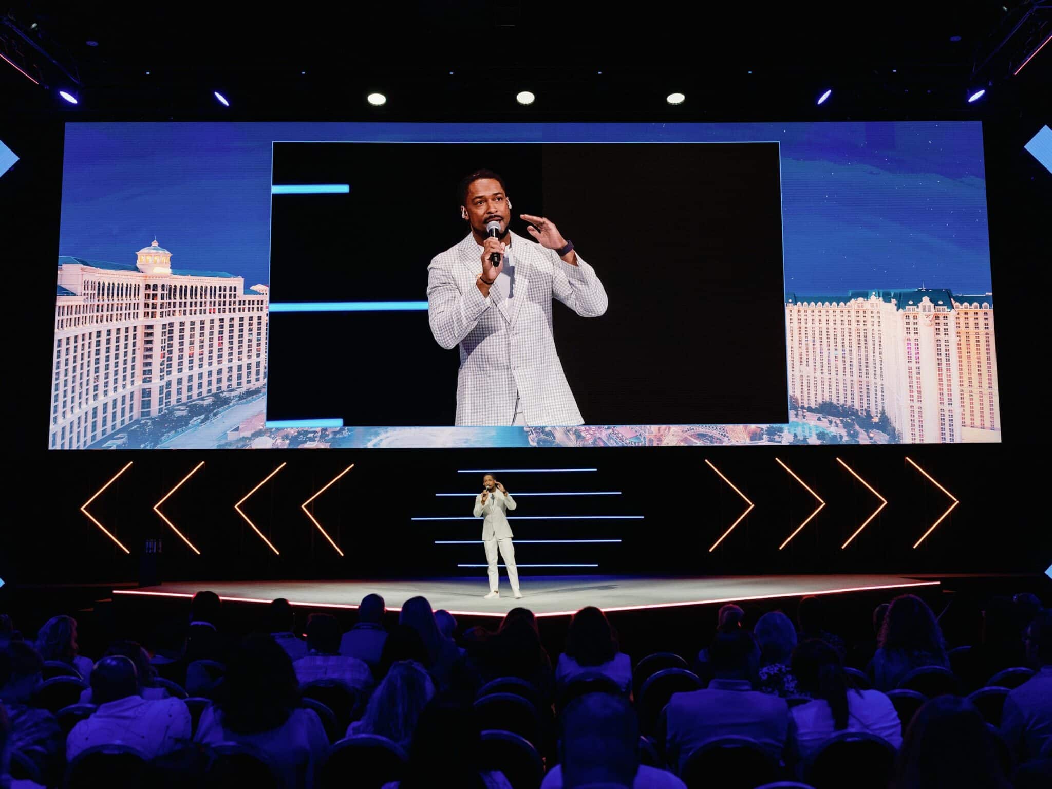 Corporate Emcee Will Gill on stage and big screen at a corporate event in Las Vegas.jpeg