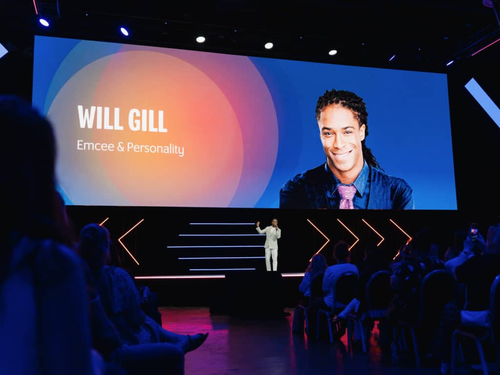 Corporate emcee Will Gill on stage and screen at a corporate event in Las Vegas