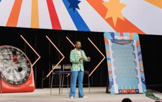 Corporate DJ Will Gill in a pineapple suit hosting an interactive game on stage