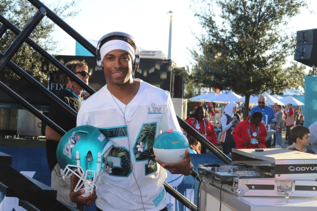 Orlando Corporate Event DJ Will Gill at Superbowl, holding a football helmet