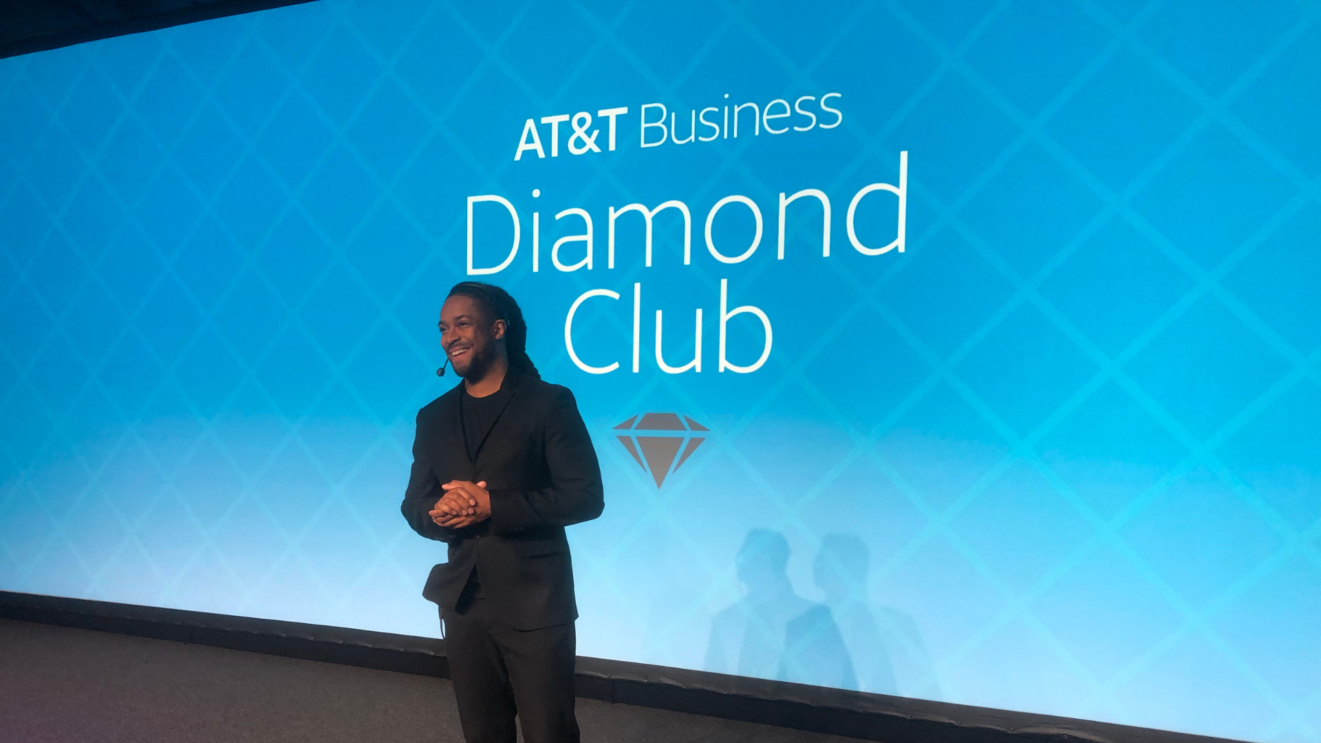 Houston Corporate Event Emcee Will Gill on stage in front of a backdrop that says AT&T business diamond club