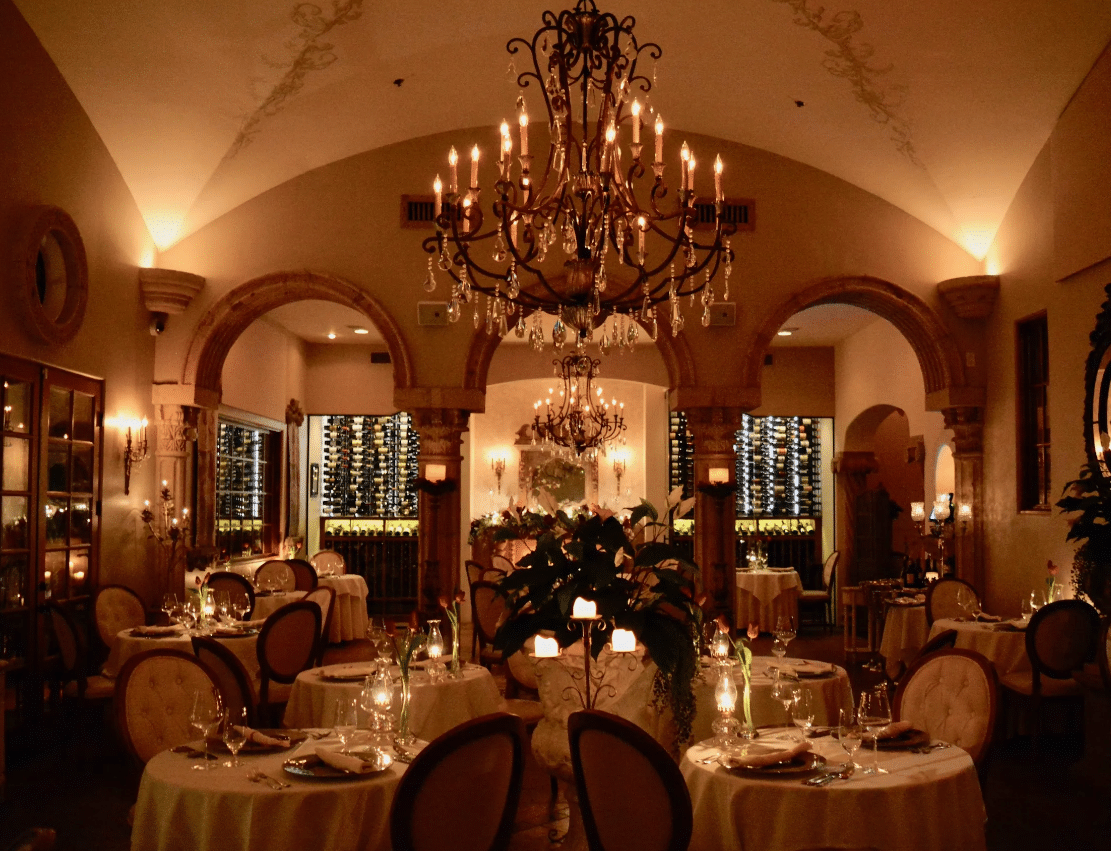Elegant reception hall with chandeliers tables and floral decor Scottsdale