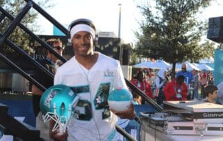 Toronto Corporate Event DJ Will Gill at Superbowl, holding a football helmet