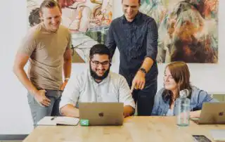 Four people choosing which Virtual Sales Kickoff Platforms to use