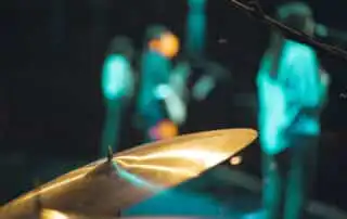 A drum and three people that's a member of corporate band