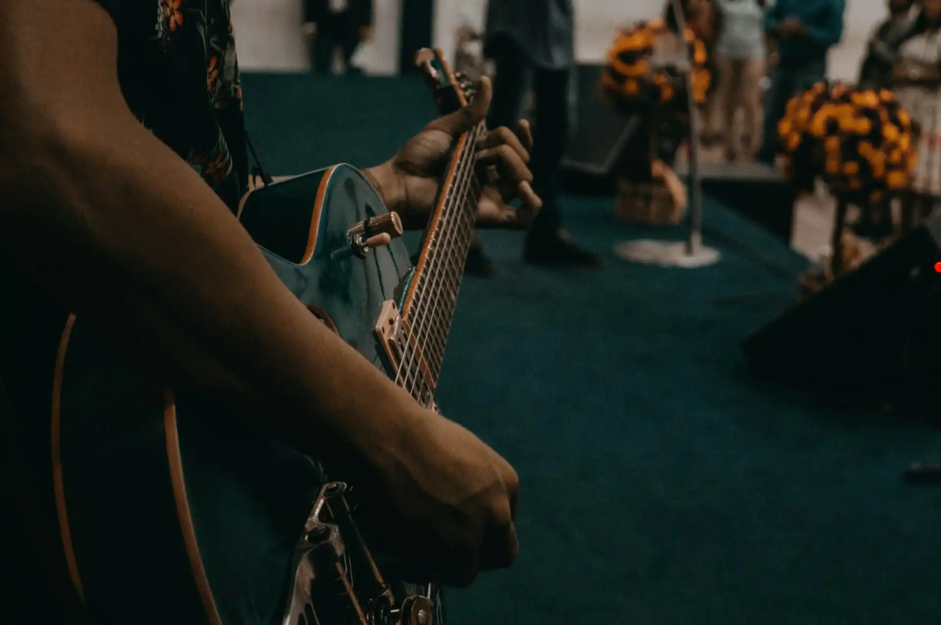 A person holding a guitar is a member of a live bands for corporate events