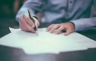 A man writing an insurance paper for band