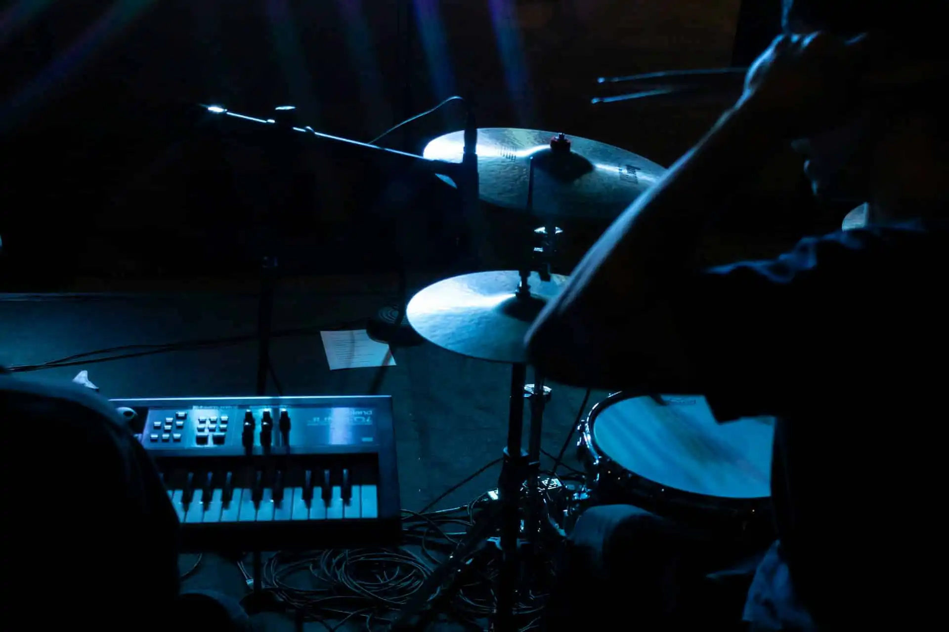 Two people behind a drum and piano playing for event