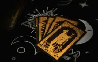 A set of four tarot cards with black and gold designs, including the Page of Wands, fanned out on a celestial-themed black background