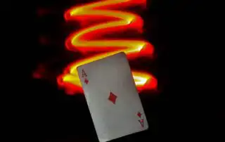 Ace of Diamonds card with red and yellow light trail on a dark background