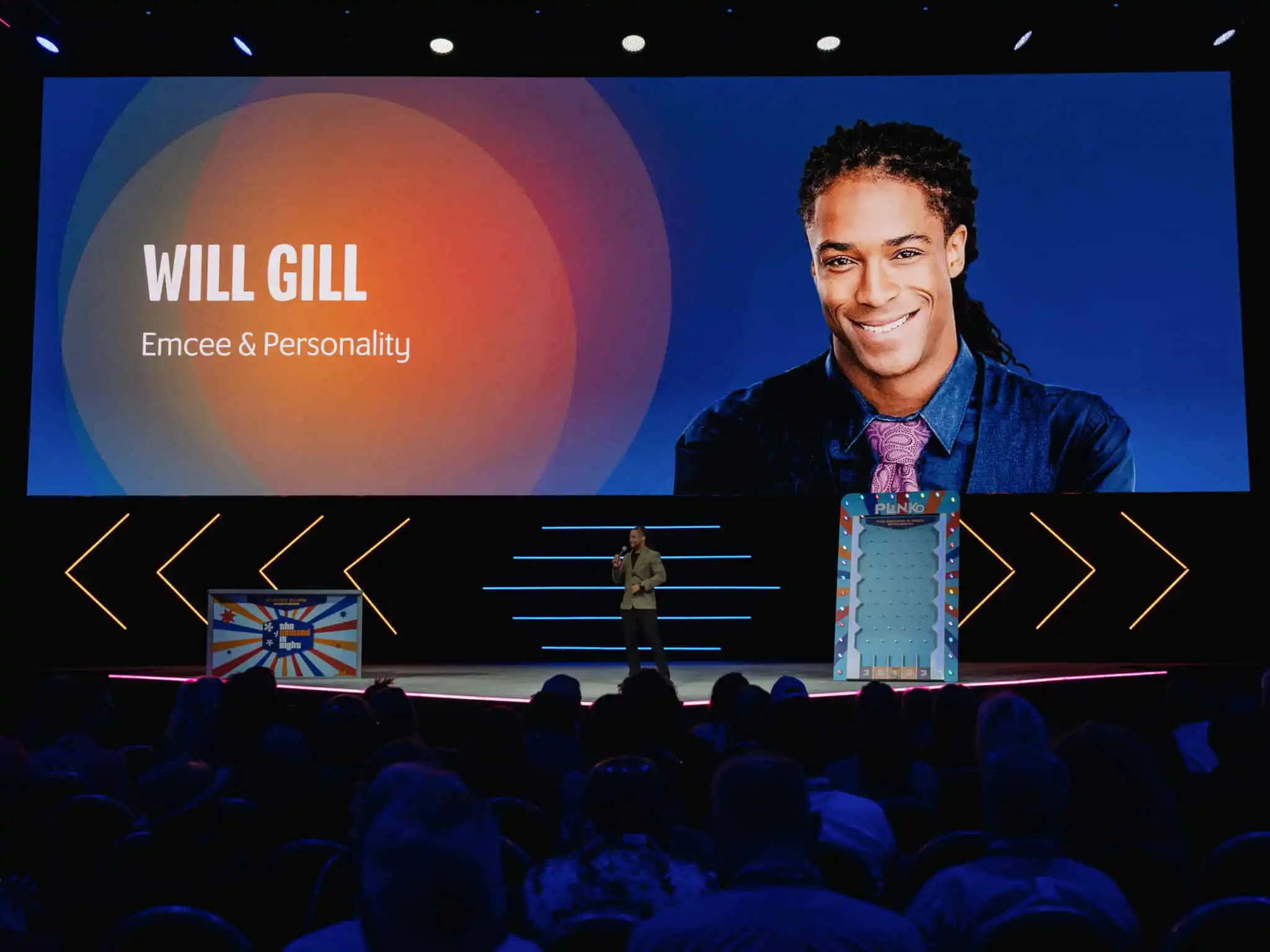 Marrakech Corporate Event MC Will Gill is onstage talking with a picture of him on the big screen