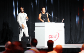Marrakech Event Emcee Will Gill is onstage teaching CDW President Chris Leahy How to DJ