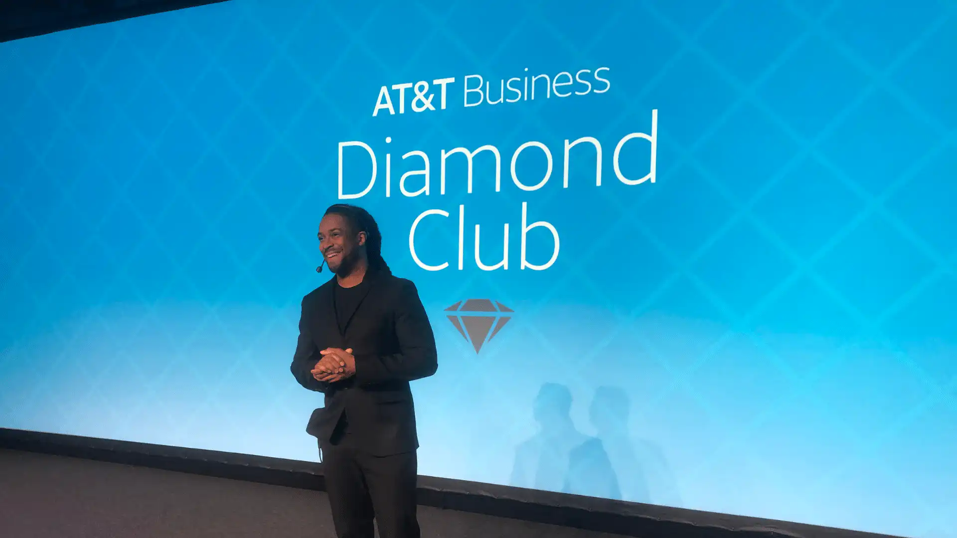 DJ Will Gill standing at company holiday parties stage with a AT&T diamond club text in the background