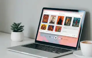 A laptop displays a music playlist with colorful album
