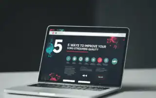 A laptop on a clean desk displaying a '5 Ways to Improve Your Song Streaming Quality,'