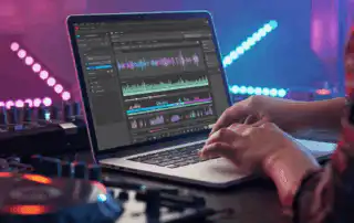 A laptop showing a DJ curates his selection songs