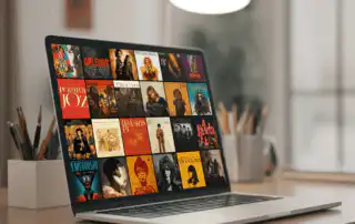 A silver laptop on a wooden desk displaying a vibrant grid of album covers, representing diverse music genres, ideal for DJs that customize playlists