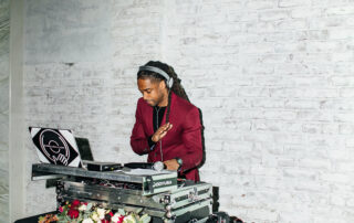 Corporate event DJ Will Gill performing in a maroon suit