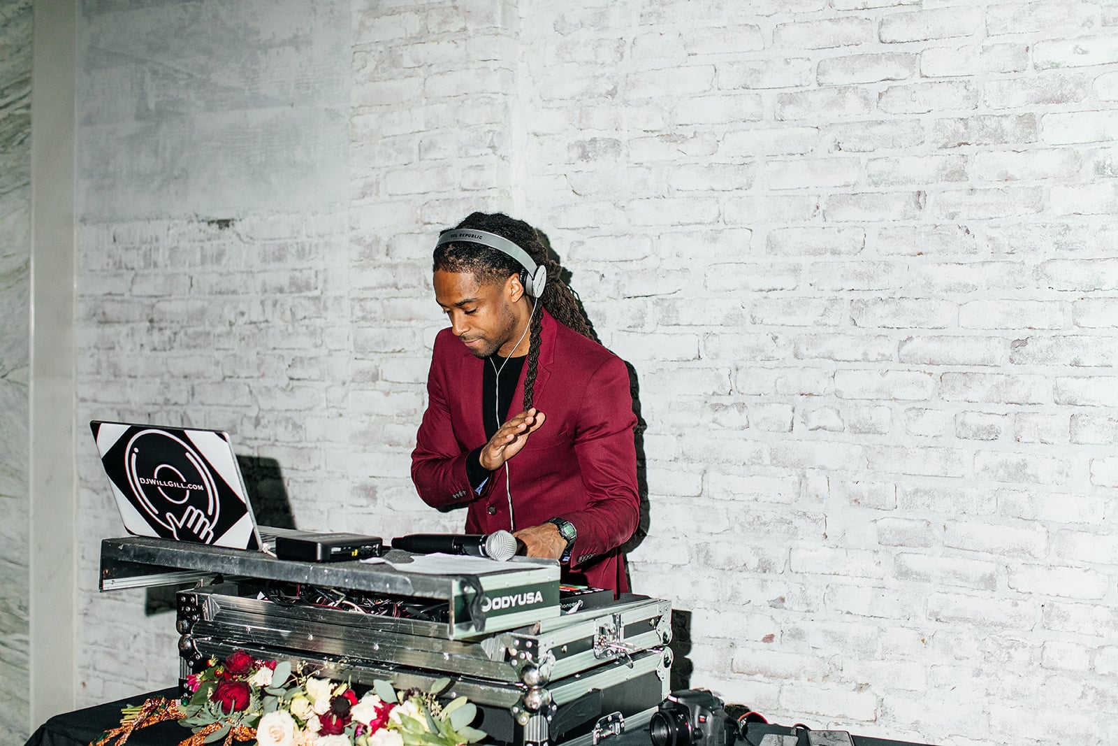 Corporate event DJ Will Gill performing in a maroon suit