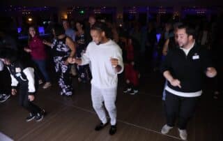 DJ Will Gill dancing with the crowd on the dance floor at a corporate event
